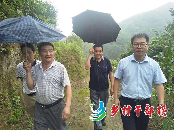 图为王李（右）冒雨在村里走访2.jpg