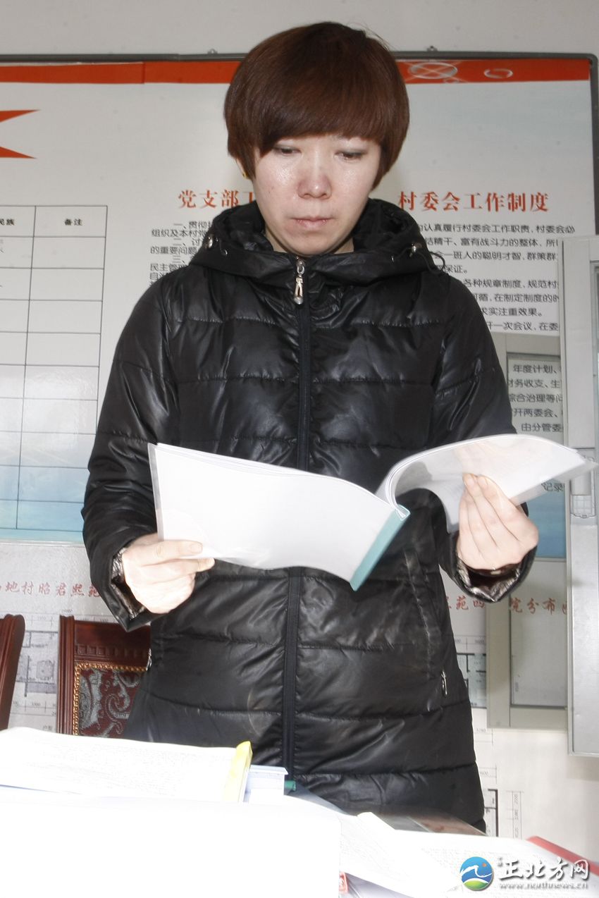 梁沙在村委会办公室整理文件