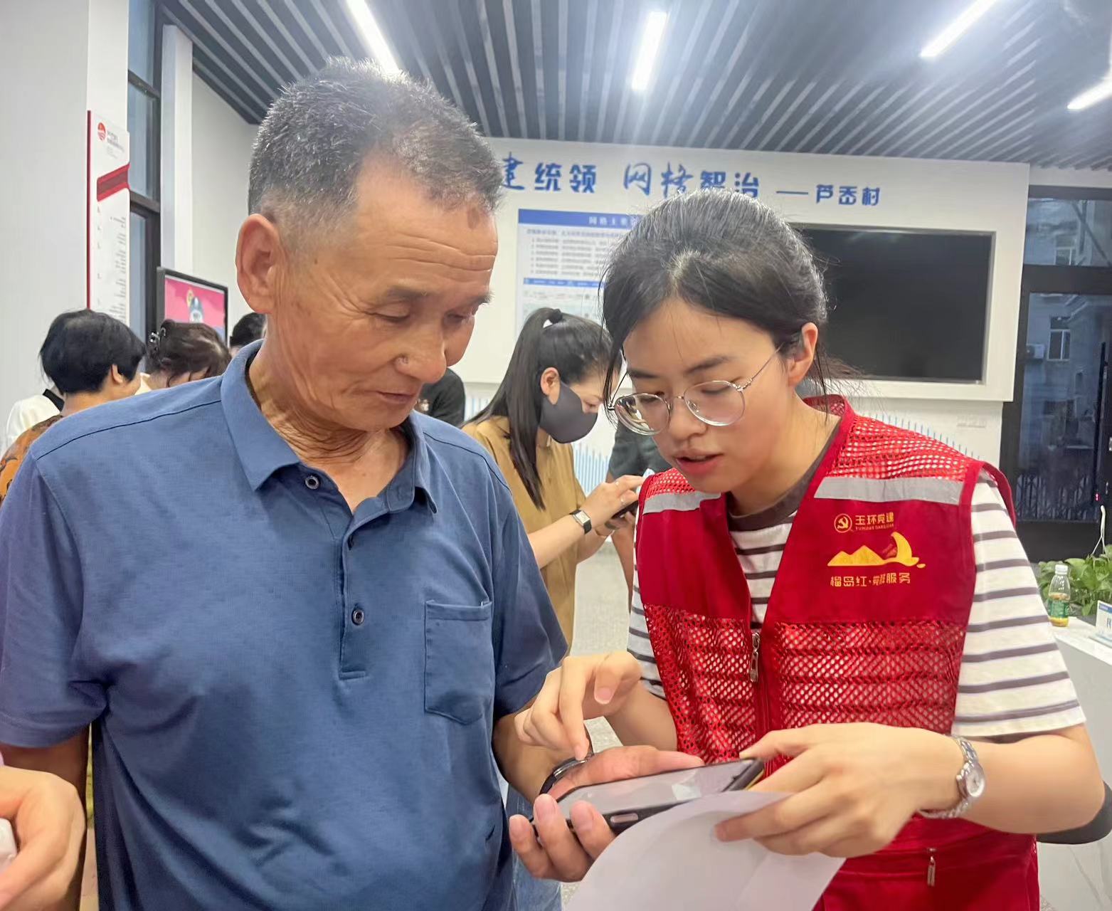 林雨涵（右）在指导老人办业务。潘豪特摄.jpg