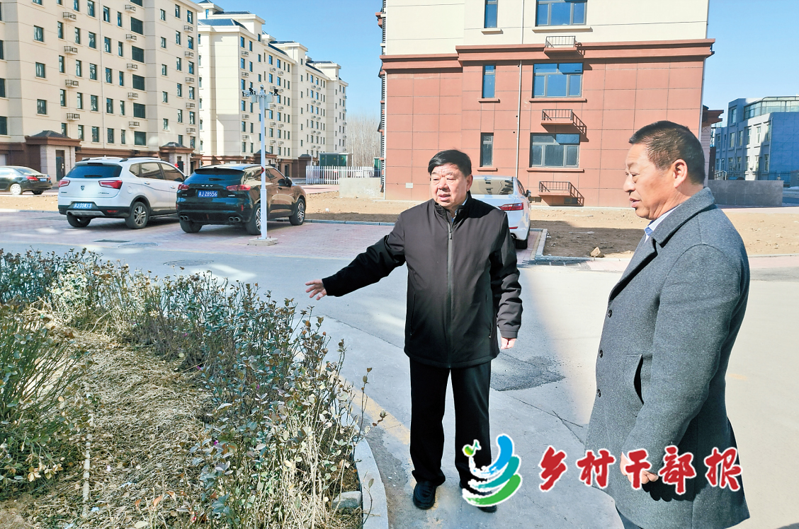 哈明江（左）和村干部商量村民小区绿化。戴绍志摄2.jpg