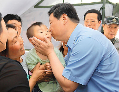 2013年5月21日至23日，习近平到四川芦山地震灾区考察时，在安置点帐篷内亲抚一小孩。 资料照片（新华社发）
