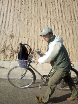 安坤推着他的自行车行走在樊-环山路上.jpg