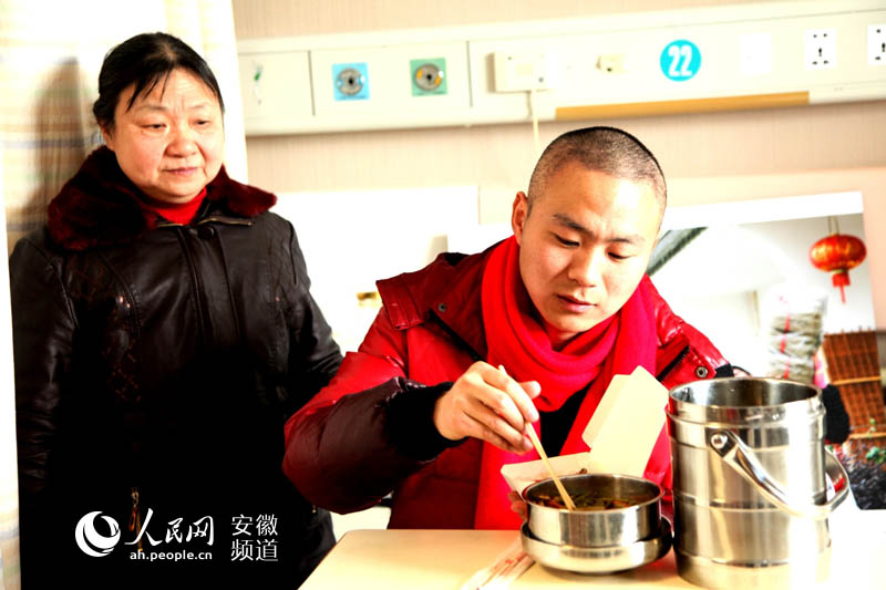 徐锋在医院里吃上妈妈亲手做的午饭，母子连心共同抗病魔。 （吴建平/摄）