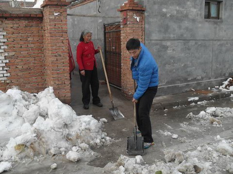 何轶轩正在老人家门口除雪
