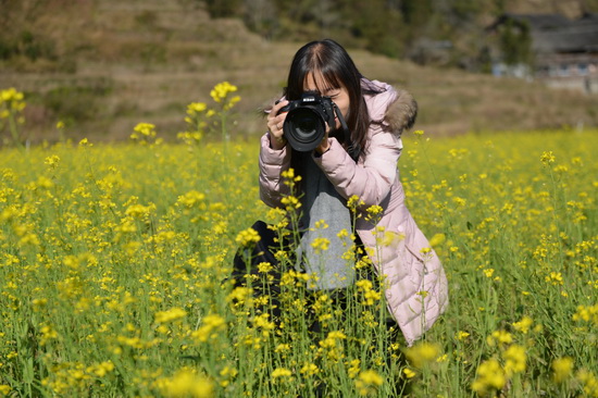 2大学生村官谢永爱在芙蓉油菜花海里摄影.jpg