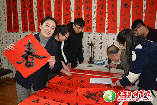 图为在“迎新春·送春联”活动中，黄元展示新蝶书画协会会员书写的作品。朱丹丹摄.JPG